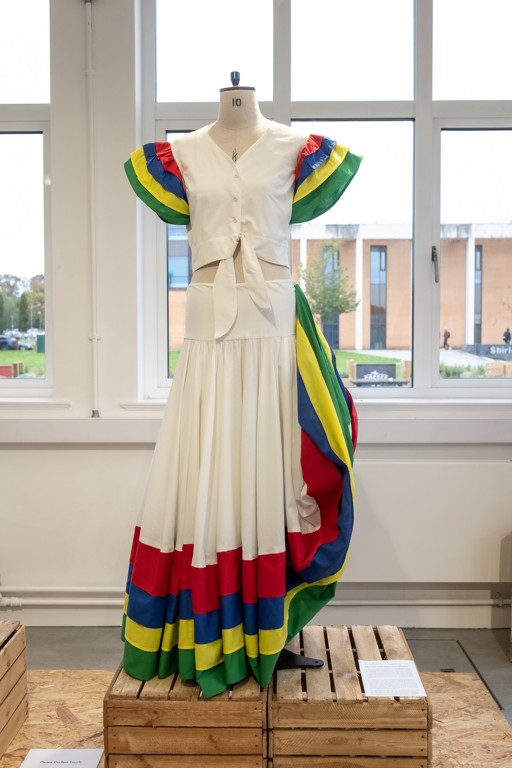 A white dancers dress with red green blue and yellow details
